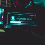hacker holding screen with virus for data breach